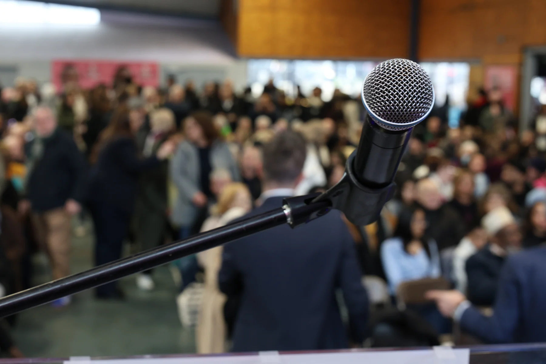 Détail du microphone, avec le public en arrière-plan.